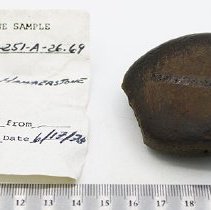 Basalt hammerstone with artifact slip with ruler