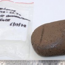 Basalt hammerstone with artifact bag and ruler