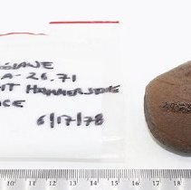Basalt hammerstone with artifact bag and ruler
