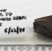 Basalt adze blank with artifact bag and ruler