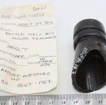 Glass bottle fragment with artifact slip and ruler