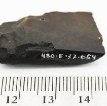 Close up of basalt adze with visible alternate id number and ruler