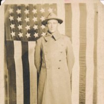 Ed (Edgar) Epperly standing in front of a US flag