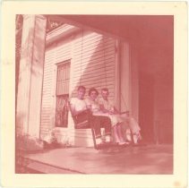 Owen Alexander, Cornelia Elmore, and A.P. Elmore sitting on porch swing