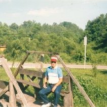 A.P. Elmore sitting on a wooden bench