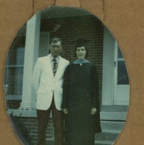 Cornelia Elmore in graduation cap and gown standing next to A.P. Elmore