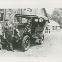 (66) 1910 Auburn with Two Men Pictured in Front of Stone Buildings