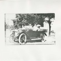 (86) 1911 Auburn Front 3/4 View, Top Down, with Two People Seated in Car