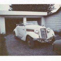 (730) 1935 Auburn Cabriolet in Front of Garage Being Pulled by Another Car