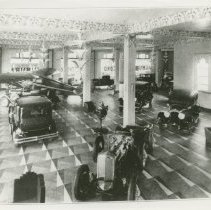 (350) North Showroom of Admin Building with Many Autos and Airplane in Shot