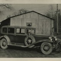 (105) 1929 Cord L-29 Sedan, 3/4 front right profile,farm building behind