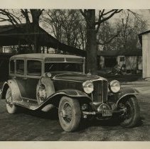 (94) 1929 Cord L-29 Sedan, front view, on a factory grounds