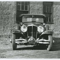 (111) 1929 Cord L-29, front view, in front of an industrial building