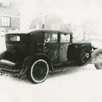 (286)1930 Duesenberg in a snowy residential setting with man in car