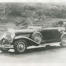 (36) 1930 Duesenberg J Rollston Convertible Victoria, brick wall behind