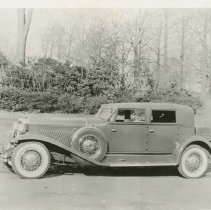 (301) 1932 Duesenberg J Beverly Sedan, left profile, wooded area behind