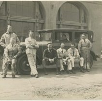 (653)8 men, gathered around an auto, August Duesenberg at the wheel