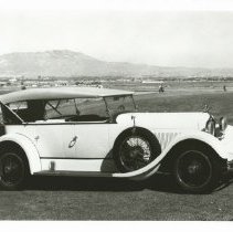 1925 Duesenberg X Phaeton with a mountain-side community in background