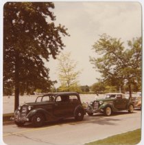 1936 Auburn 654 brougham in front of a 1935 Auburn convertible parking alongside a road