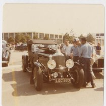 Bentley in a parking lot with spectators looking in the engine compartment
