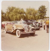 Chrysler convertible in a parking lot with spectators around