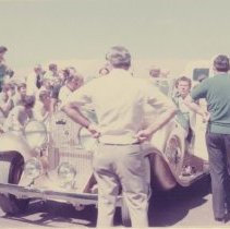 Festival goers around a Cadillac V-8