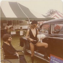 Larry Flynt with a woman holding white dog next to unidentified car