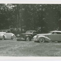 Cord 810/812 group on grass in front of tree line.