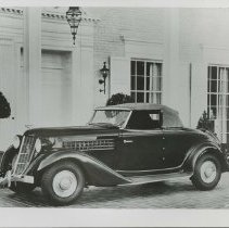 1936 Auburn 654 Cabriolet on paved bricks in front of home.