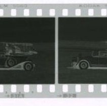 Cord L-29 Cabriolet in front of Stinson airplane out in field.