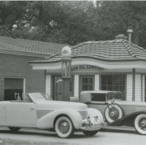 Cord 810-812 with Cord L-29 Cabriolet in front of Sun Oil Company gas station.