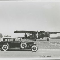 Black and white image of Cord L-29 Sedan on road in front of Stinson Aircraft.