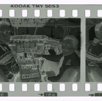 Filmstrip of two unidentified men looking camera in an airplane cockpit