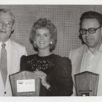 Black and white photo of Richard and Linda Kughn and Oliver Ehresman holding award plaques