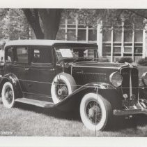 1986 black and white photo of a 1932 Auburn sedan parked in a grassy park