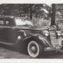 1986 black and white photo of a 1935 Auburn 851 sedan in a grassy park