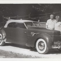 1986 black and white photo of an unidentified couple standing behind a Cord 810-812 phaeton