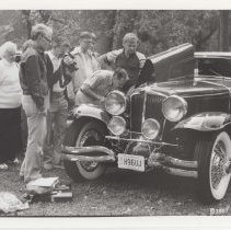 Black and white photo of a group of people watching Paul Bryant