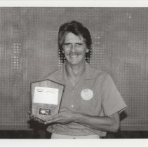 Black and white photo of a man holding his ACD Festival award