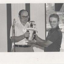 Two men holding an award trophy at the awards banquet