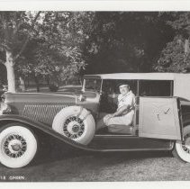 Man sitting inside of a 1931 Auburn phaeton in a park