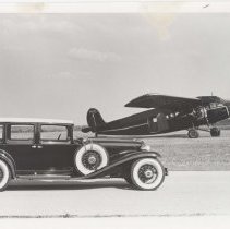 1933 Auburn sedan next to an airplane