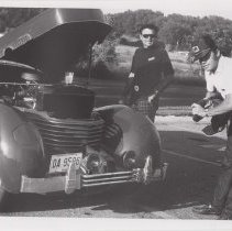 Two men looking into the hood of a 1936 Cord 810 phaeton