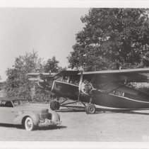 Cord 810-812 phaeton next to a Stinson plane in a field