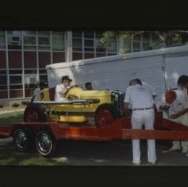 Group getting racecar onto trailer