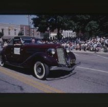 1935 - 1936 Auburn Cabriolet driving down Main Street