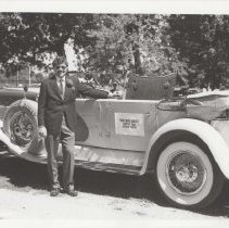 Tom Monaghan standing next to the Duesenberg J-107