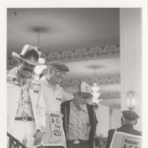 Four men on the museum showroom staircase wearing Hoosier ACD Tour banners