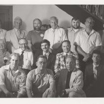 Large group of men by the museum showroom staircase