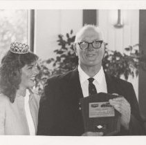 Mac Hunter holding his ACD Club award and a woman wearing a tiara